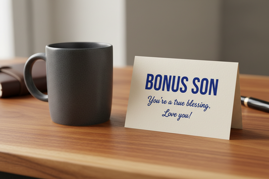 A dark-colored custom coffee mug sitting on a wooden desk next to a heartfelt greeting card for a bonus son.